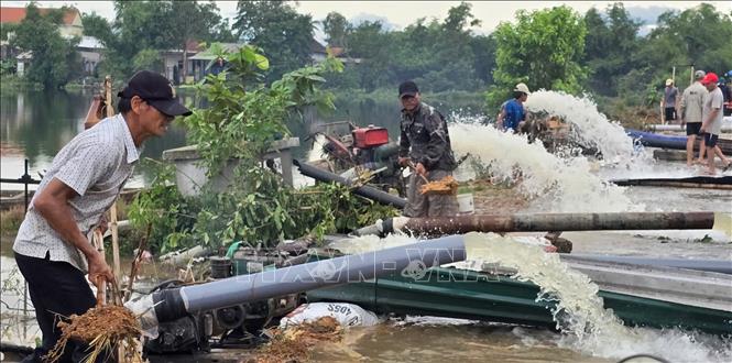 Hợp tác xã nông nghiệp Phú Hồ, xã Phú Hồ, huyện Phú Vang huy động nhân lực, máy bơm tiêu úng cứu lúa cho nông dân. Ảnh: Tường Vi - TTXVN