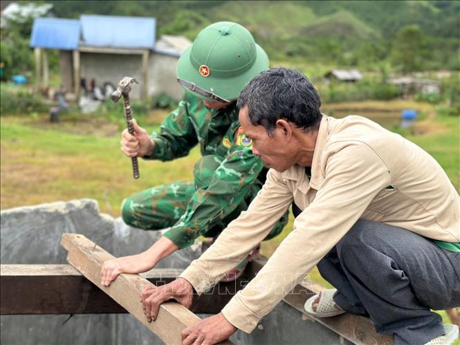Bộ đội biên phòng cửa khẩu A Đớt hỗ trợ người dân huyện A Lưới khắc phục dông lốc. Ảnh: TTXVN phát