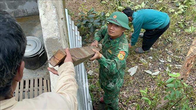 Bộ đội biên phòng cửa khẩu A Đớt hỗ trợ người dân huyện A Lưới khắc phục dông lốc. Ảnh: TTXVN phát