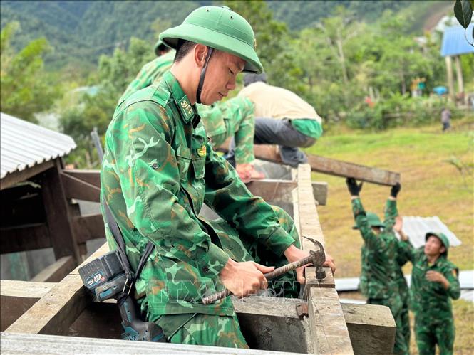 Bộ đội biên phòng cửa khẩu A Đớt hỗ trợ người dân huyện A Lưới khắc phục dông lốc. Ảnh: TTXVN phát