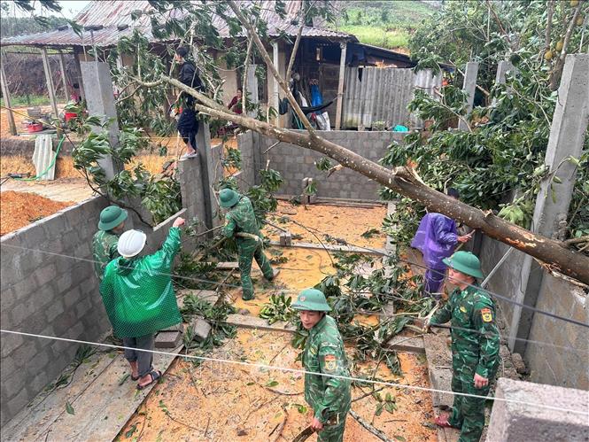 Bộ đội biên phòng cửa khẩu A Đớt hỗ trợ người dân huyện A Lưới khắc phục dông lốc. Ảnh: TTXVN phát