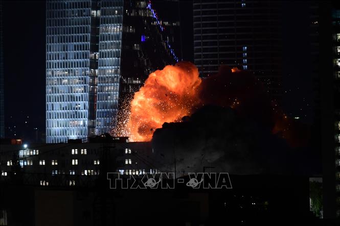 Khói lửa bốc lên từ toà nhà bị trúng tên lửa của Iran tại Tel Aviv, Israel tối 14/6/2025. Ảnh: THX/TTXVN