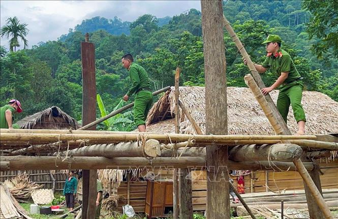 Lực lượng công an tham gia hỗ trợ giúp đồng bào Đan Lai tháo dỡ nhà sàn. Ảnh: TTXVN phát 