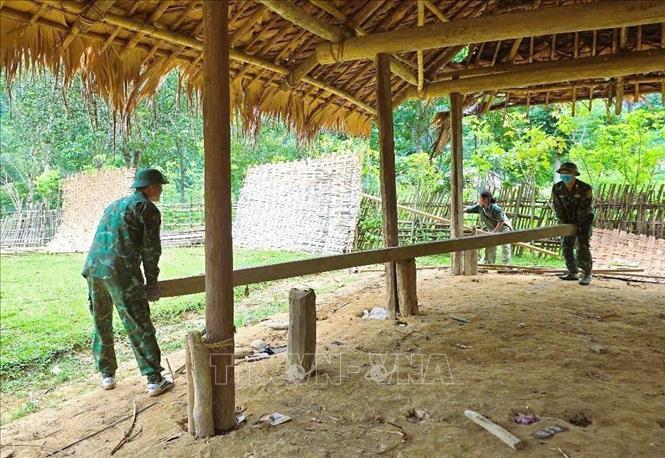 Bộ đội biên phòng Đồn Biên phòng Môn Sơn (BĐBP Nghệ An) hỗ trợ giúp người dân Đan Lai tháo dỡ nhà, di chuyển đồ đạc. Ảnh: TTXVN phát 
