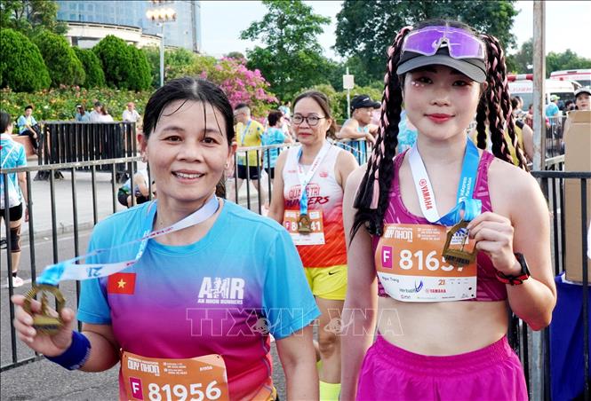 Các vận động viên Việt Nam vui mừng khi nhận huy chương hoàn thành chặng chạy (finisher medal). Ảnh: Lê Phước Ngọc – TTXVN 