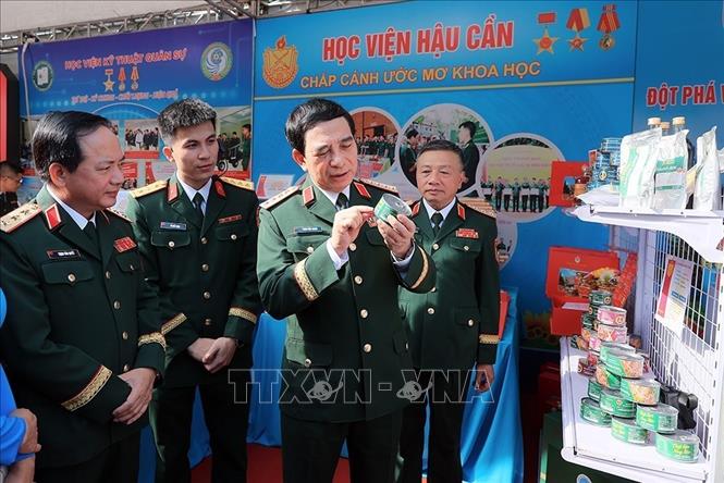 Đại tướng Phan Văn Giang, Bộ trưởng Bộ Quốc phòng với các đại biểu tham quan khu trưng bày sản phẩm tuổi trẻ sáng tạo. Ảnh: An Đăng - TTXVN