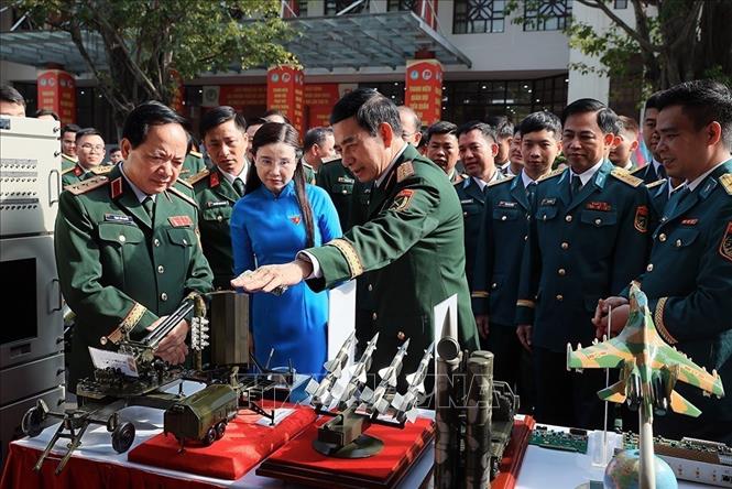 Đại tướng Phan Văn Giang, Bộ trưởng Bộ Quốc phòng với các đại biểu tham quan khu trưng bày sản phẩm tuổi trẻ sáng tạo. Ảnh: An Đăng - TTXVN