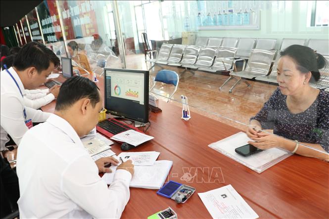 Cán bộ giải quyết thủ tục hành chính cho người dân. Ảnh: Dương Chí Tưởng - TTXVN