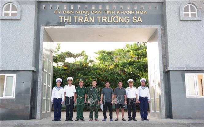 Ông Nhanh (thứ 3, từ phải sang) chụp ảnh lưu niệm cùng cán bộ, chiến sĩ thị trấn Trường Sa trước khi rời đảo. Ảnh: TTXVN phát