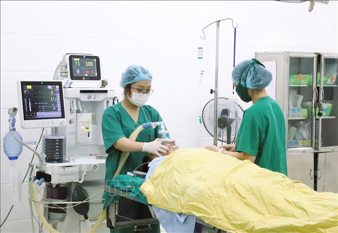 Các y, bác sĩ Bệnh viện Ung Bướu Nghệ An thực hiện kiểm tra các chỉ số và tiến hành kỹ thuật gây mê cho bệnh nhân được phẫu thuật cắt đoạn đại trực tràng. Ảnh: Xuân Tiến-TTXVN 