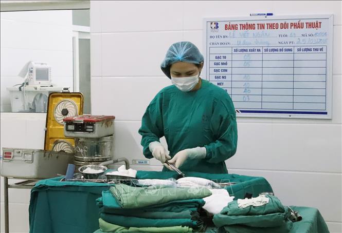 Phẫu thuật viên Bệnh viện Ung Bướu Nghệ An kiểm tra, chuẩn bị hệ thống các bộ dụng cụ y tế, thuốc men, máy móc, kỹ thuật… cho kíp y, bác sĩ trước khi thực hiện ca mổ cho bệnh nhân. Ảnh: Xuân Tiến-TTXVN 