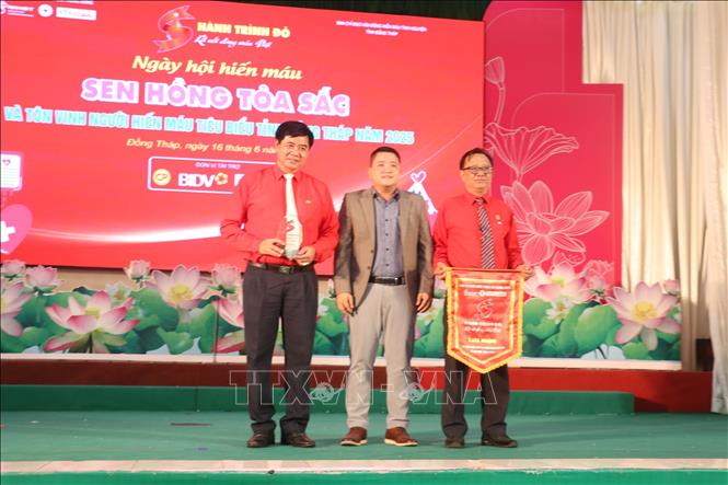 Ông Nguyễn Tuấn Khởi, Phó Trưởng Ban Tổ chức Chương trình “Hành trình Đỏ” Trung ương trao cờ lưu niệm và biểu trưng cho tỉnh Đồng Tháp. Ảnh: Nguyễn Văn Trí - TTXVN