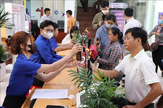 Lực lượng Đoàn viên thanh niên hỗ trợ người dân thao tác trên ứng dụng điện thoại VNeID. Ảnh: Văn Hướng – TTXVN