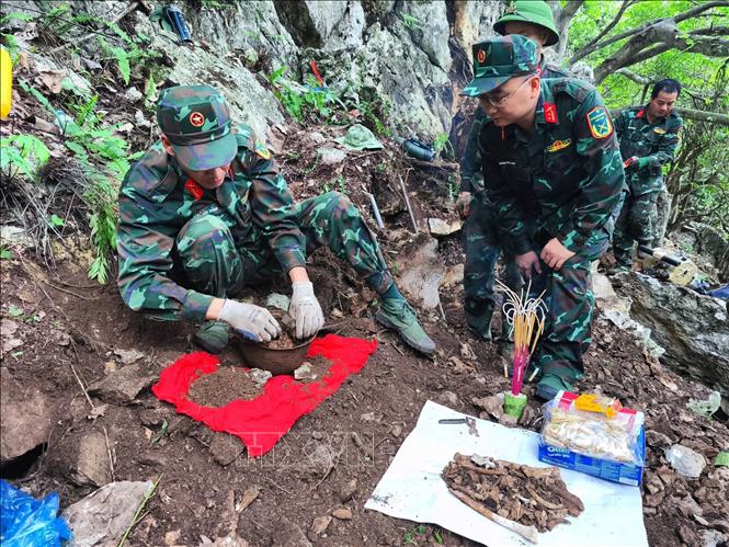 Trung tá Nguyễn Trung Kiên, Phó Chủ nhiệm Chính trị, Bộ Chỉ huy Quân sự tỉnh Hà Giang, trực tiếp chỉ đạo cất bốc 4 bộ hài cốt liệt sĩ vừa được tìm thấy tại khu vực Điểm cao 211. Ảnh: TTXVN phát