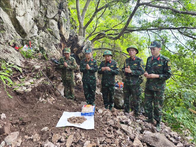 Đội tìm kiếm, quy tập hài cốt liệt sĩ thắp hương tưởng niệm khi vừa phát hiện một hài cốt liệt sĩ tại khu vực Điểm cao 211. Ảnh: TTXVN phát