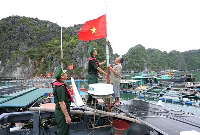 Bộ đội Biên phòng Hải Phòng tặng cờ Tổ quốc cho thuyền trưởng Nguyễn Văn Ánh, làm nghề khai thác thuỷ sản xa bờ, thị trấn Cát Bà, thành phố Hải Phòng trước khi ra khơi khai thác thuỷ sản. Ảnh: Vũ Sinh - TTXVN
