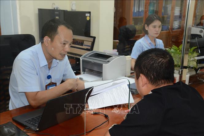 Công chức lĩnh vực xây dựng phường Cao Xanh (mới) hướng dẫn người dân thực hiện thủ tục hành chính. Ảnh: Thanh Vân - TTXVN