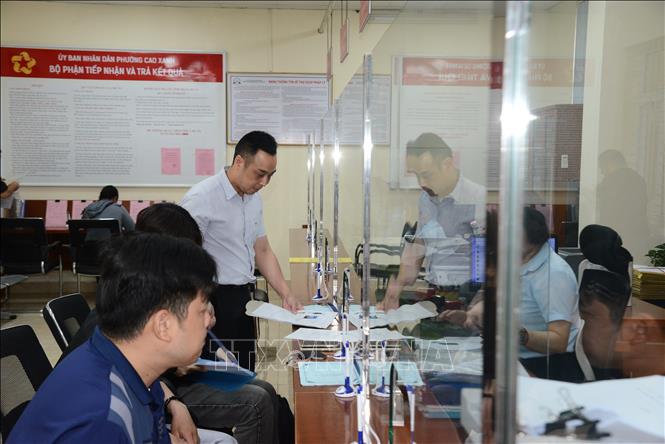 Ông Nguyễn Hải Ngọc (áo trắng), được phân công giữ chức vụ Phó Chủ tịch UBND phường Cao Xanh (mới) kiểm tra hoạt động tiếp nhận, giải quyết thủ tục hành chính tại phường. Ảnh: Thanh Vân - TTXVN  