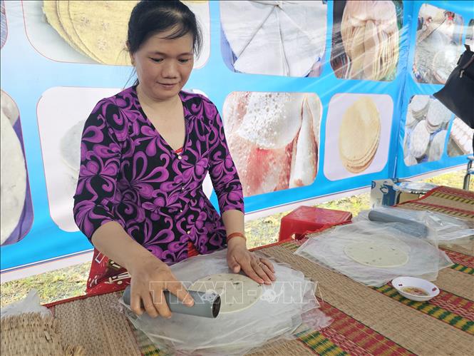 Bột nếp sau khi giã xong sẽ được cán thành, thành hình tròn để làm thành bánh phồng Sơn Đốc trứ danh. Ảnh: Chương Đài - TTXVN