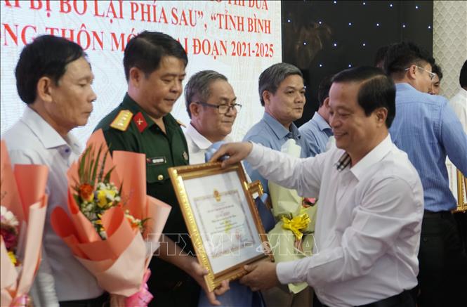 Ông Nguyễn Tuấn Thanh, Phó Chủ tịch UBND tỉnh Bình Định tặng bằng khen cho các tập thể và cá nhân có thành tích xuất sắc trong các phong trào thi đua giảm nghèo. Ảnh: Đình Quân-TTXVN