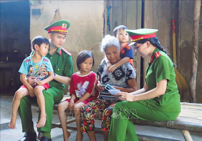 Lực lượng công an xã trực tiếp đi đến các hộ gia đình ở từng thôn, xóm làng biển huyện Quỳnh Lưu hướng dẫn người dân cài đặt định danh điện tử, tích hợp Thẻ bảo hiểm Y tế vào ứng dụng VNeID trên điện thoại. Ảnh: Xuân Tiến-TTXVN 