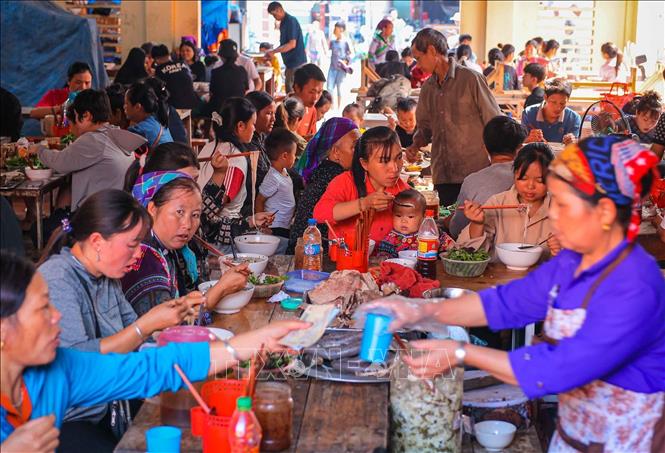 Người dân và du khách thưởng thức các món ăn truyền thống địa phương tại chợ phiên Bắc Hà. Ảnh: Hoàng Hiếu - TTXVN