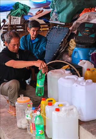 Rượu Bắc Hà được chưng cất từ ngô và men lá hồng mi, nổi tiếng với hương vị thơm, cay nồng đặc trưng được bày bán nhiều tại chợ. Ảnh: Hoàng Hiếu - TTXVN