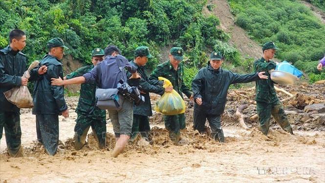 Phóng viên Cơ quan thường trú TTXVN tại Điện Biên Trịnh Xuân Tư băng qua suối nước chảy siết với sự giúp đỡ của các chiến sĩ Biên phòng để kịp thời thông tin về tình hình mưa lũ tại địa bàn, tháng 7/2024. Ảnh: TTXVN 