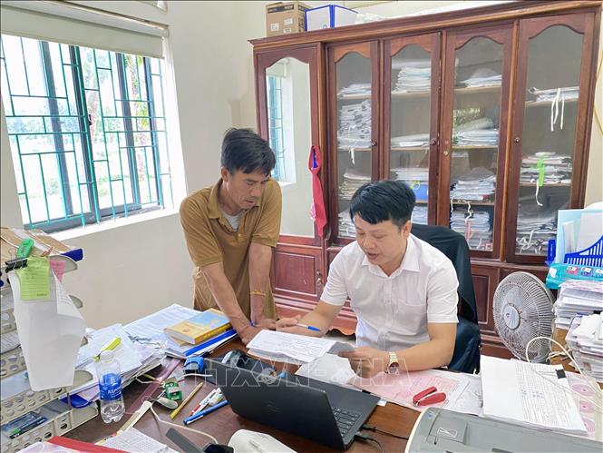 Cán bộ địa chính thị trấn Lộc Hà (huyện Thạch Hà) hướng dẫn người dân làm thủ tục về điều chỉnh giấy chứng nhận quyền sử dụng đất. Ảnh: Hữu Quyết – TTXVN