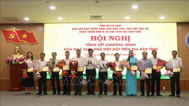 Ông Phạm Thành Ngại, Phó Bí thư Tỉnh ủy, Chủ tịch UBND tỉnh Cà Mau cùng ông Lê Thanh Triều, Chủ tịch Ủy ban MTTQ Việt Nam tỉnh Cà Mau trao bảng tri ân và hoa cho đại diện các đơn vị tài trợ Chương trình xóa nhà tạm, nhà dột nát tại Cà Mau Ảnh: Kim Há – TTXVN