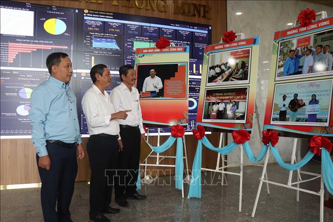 Lãnh đạo tỉnh Cà Mau tham quan khu trưng bày những hình ảnh sinh động về hoạt động, phong trào xóa nhà tạm, nhà dột nát trên địa bàn tỉnh. Ảnh: Kim Há – TTXVN