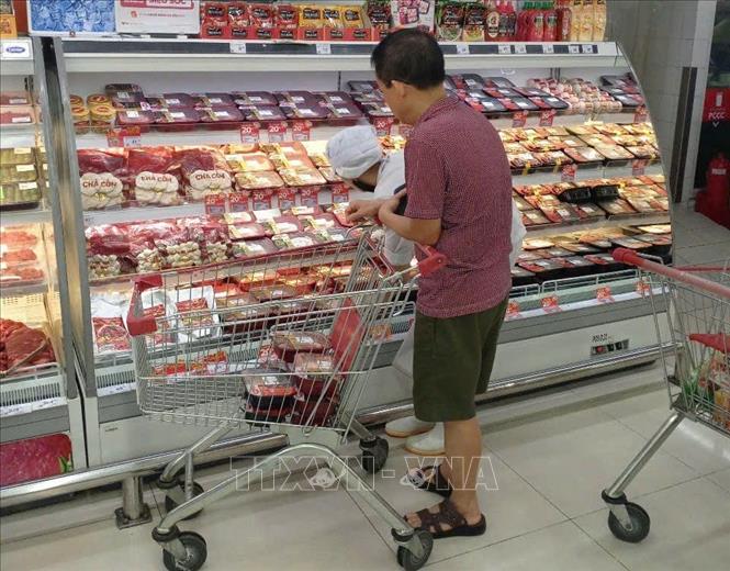 Người tiêu dùng TP. Hồ Chí Minh lựa chọn thịt ủ mát. Ảnh: Hương Giang - TTXVN
