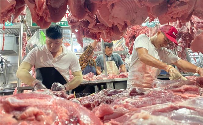 Nhân viên pha lóc thịt lợn tại chợ đầu mối nông sản thực phẩm Hóc Môn. Ảnh: Hương Giang - TTXVN