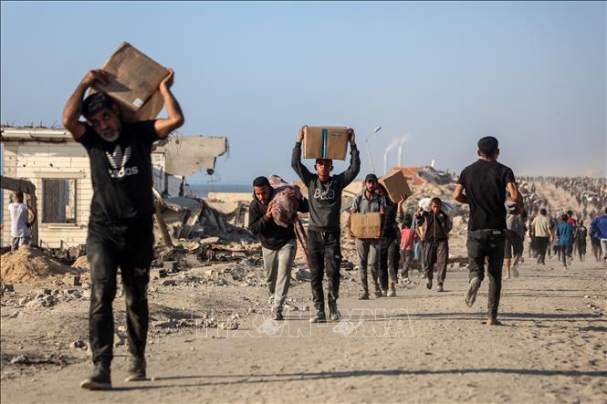 Người dân Palestine nhận hàng cứu trợ tại Gaza. Ảnh: THX/TTXVN