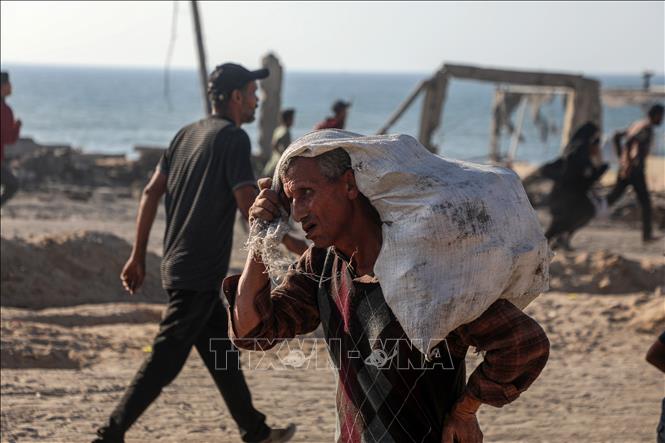 Người dân Palestine nhận hàng cứu trợ tại Gaza. Ảnh: THX/TTXVN