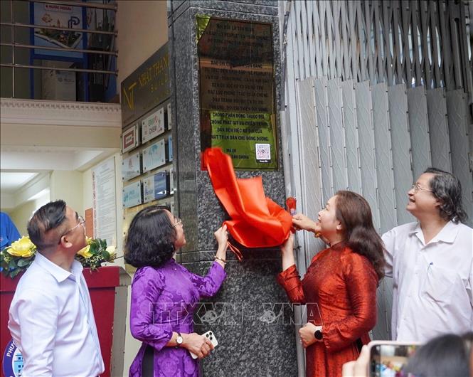 Các đại biểu thực hiện nghi thức ra mắt bảng hiệu Di tích Lịch sử cấp Quốc gia Trụ sở báo Dân Chúng. Ảnh: Thu Hương - TTXVN