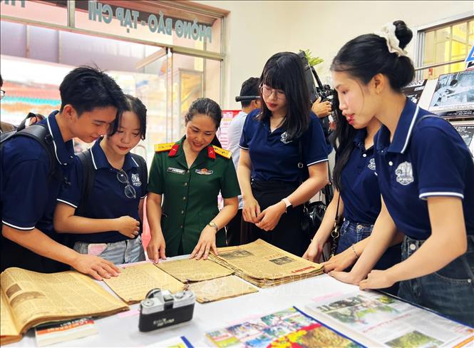 Nữ quân nhân thuyết minh tư liệu báo chí lịch sử cho các bạn trẻ. Ảnh: Ánh Tuyết - TTXVN