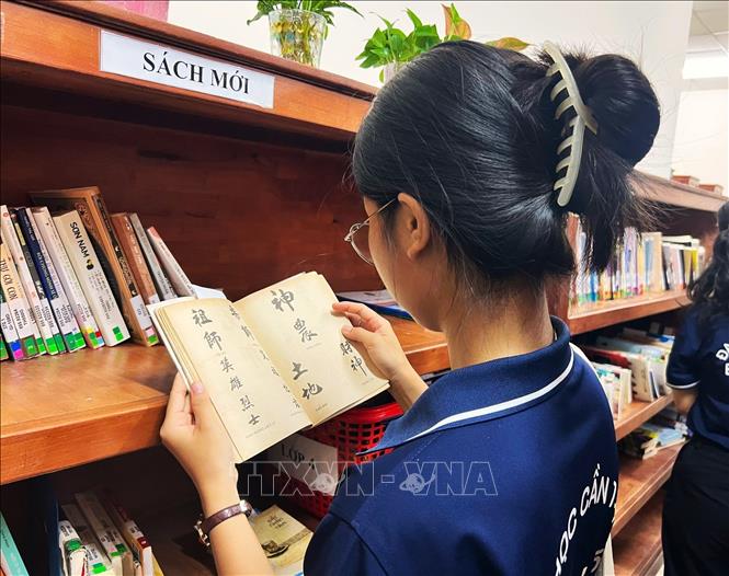 Bạn trẻ tìm hiểu tư liệu chữ Hán. Ảnh: Ánh Tuyết - TTXVN