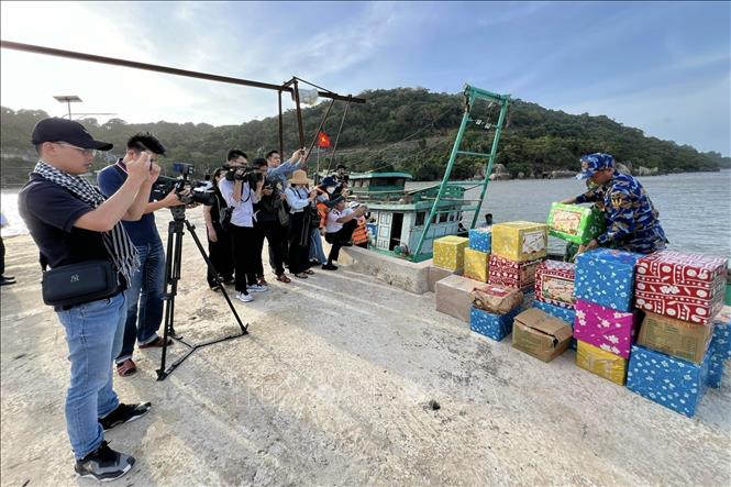Phóng viên tác nghiệp trong chuyến công tác thăm, chúc tết cán bộ, chiến sĩ nhân dân và các lực lượng trên vùng biển Tây Nam. Ảnh: TTXVN phát