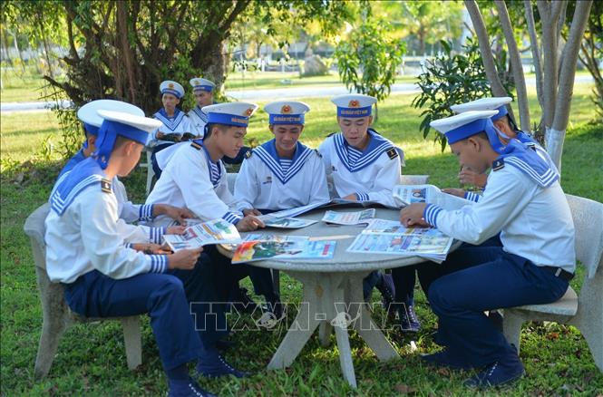 Các chiến sĩ Vùng 5 Hải quân đọc báo trong giờ nghỉ giải lao. Ảnh: TTXVN phát