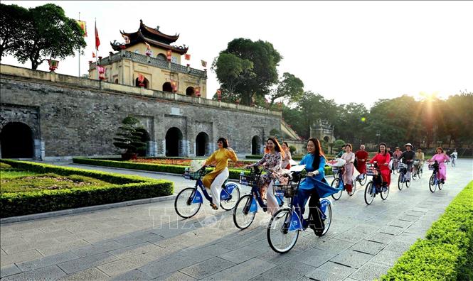 Phụ nữ Thủ đô trong trang phục áo dài đạp xe qua các điểm di sản của Hà Nội trong chương trình “Áo dài kết nối du lịch và di sản Hà Nội lần thứ nhất - năm 2023”, được phóng viên ảnh ghi lại. Ảnh: Nhật Anh – TTXVN