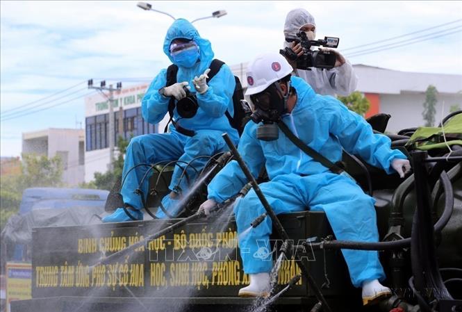 Phóng viên TTXVN tại Đà Nẵng tác nghiệp trên thùng xe phun thuốc khử trùng các khu vực có nguy cơ lây nhiễm COVID-19 cao trên địa bàn quận Sơn Trà (TP. Đà Nẵng). Ảnh: Trần Lê Lâm – TTXVN