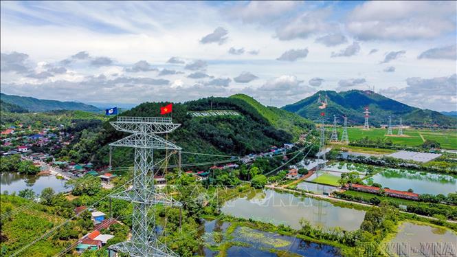 Phóng viên đưa tin ảnh về việc hoàn thành đường dây 500kV mạch 3 để đảm bảo việc cung ứng điện thông suốt trên cả nước. Ảnh: Huy Hùng – TTXVN