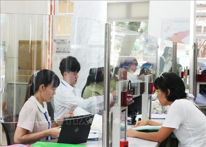 Cán bộ, công chức tại Trung tâm Hành chính công Quận 1 (phường Sài Gòn mới) đang khẩn trương xử lý hồ sơ. Ảnh: Hữu Duyên - TTXVN 