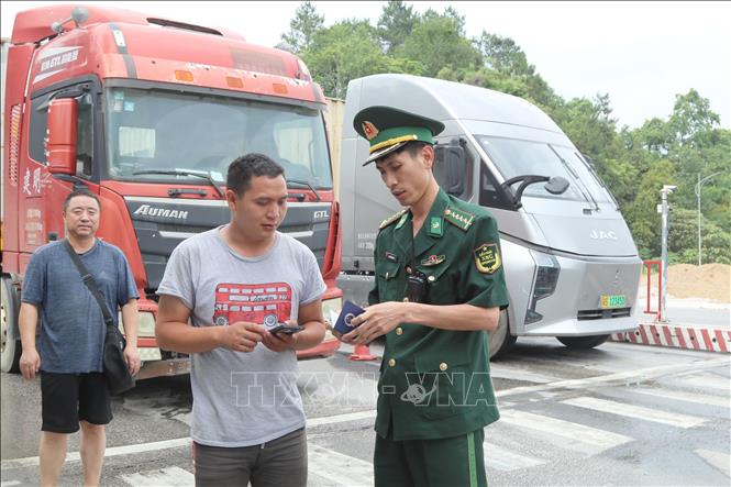 Lực lượng Bộ đội Biên phòng cửa khẩu quốc tế Hữu Nghị (Lạng Sơn) hướng dẫn lái xe về thủ tục nhập cảnh tại khu vực xuất nhập khẩu hàng hóa. Ảnh: Quang Duy - TTXVN
