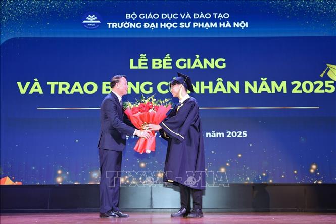Đại diện tân cử nhân tặng hoa cảm ơn lãnh đạo nhà trường. Ảnh: Thanh Tùng - TTXVN