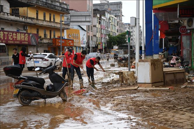 Tình nguyện viên dọp dẹp đường phố sau trận lũ lụt tại Quảng Đông, Trung Quốc. Ảnh: THX/TTXVN