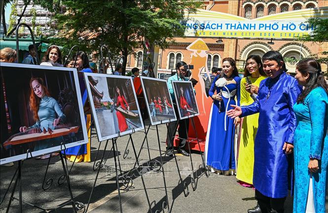 Các đại biểu tham quan triển lãm “Khoảnh khắc áo dài – Sài Gòn xưa và nay”. Ảnh: Thu Hương - TTXVN