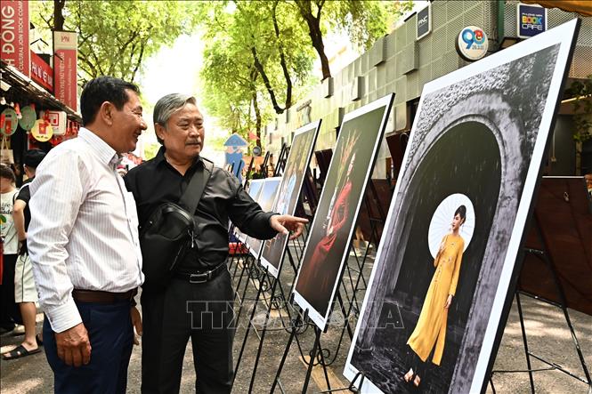 Các đại biểu tham quan triển lãm “Khoảnh khắc áo dài – Sài Gòn xưa và nay”. Ảnh: Thu Hương - TTXVN