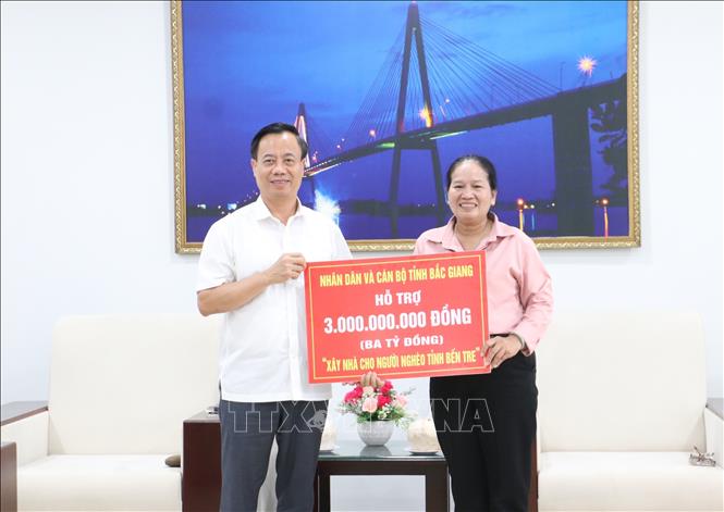 Chủ tịch Ủy ban MTTQ Việt Nam tỉnh Bắc Giang Đinh Đức Cảnh trao tặng Ủy ban MTTQ Việt Nam tỉnh Bến Tre bảng tượng trưng 3 tỷ đồng, để xây dựng 50 căn nhà Đại đoàn kết cho các hộ khó khăn về nhà ở tại tỉnh Bến Tre. Ảnh: Chương Đài - TTXVN
